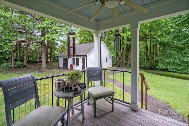 wooden terrace featuring ceiling fan and a yard