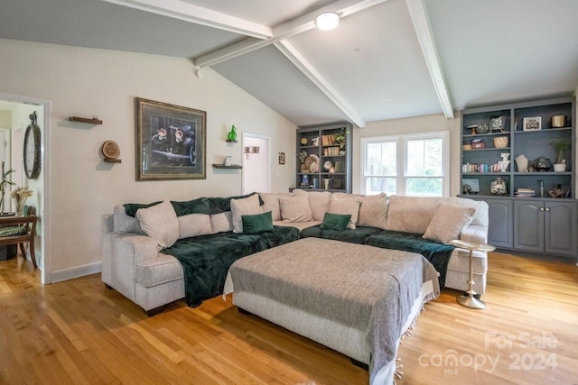 living room with vaulted ceiling with beams, light hardwood / wood-style floors, and built in features