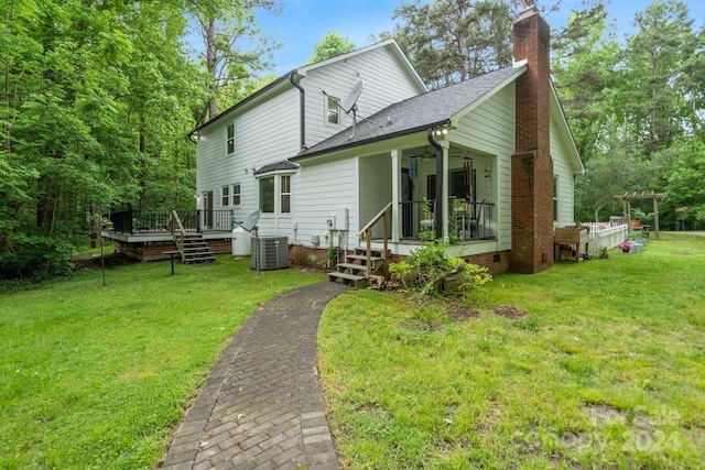 rear view of house with a lawn, central AC unit, and a deck