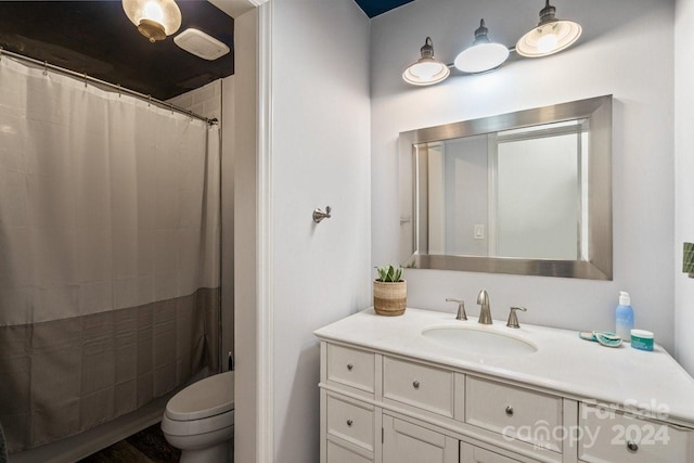 bathroom featuring a shower with shower curtain, vanity, and toilet