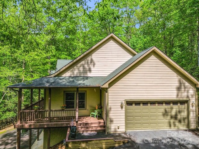 view of property with a porch and a garage