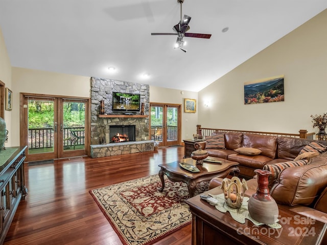 living room featuring plenty of natural light, a stone fireplace, ceiling fan, and dark hardwood / wood-style floors