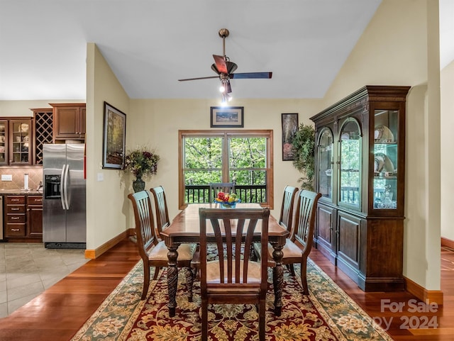 dining area with light hardwood / wood-style floors, ceiling fan, and vaulted ceiling