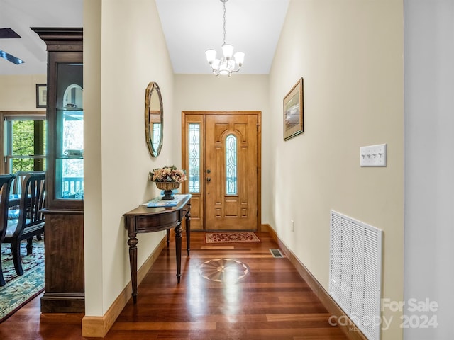 entryway featuring dark wood-type flooring and a chandelier