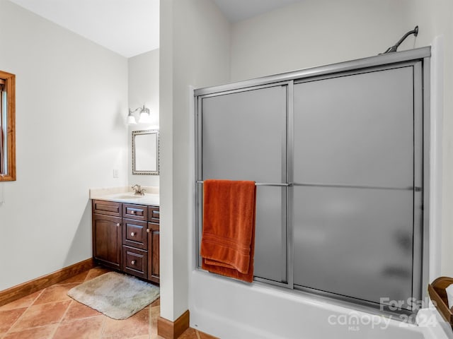 bathroom with vanity, combined bath / shower with glass door, and tile flooring