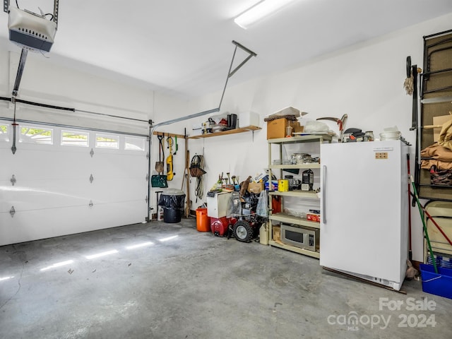 garage with white fridge and a garage door opener