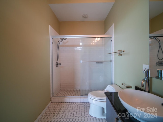 bathroom featuring tile patterned flooring, vanity, toilet, and walk in shower