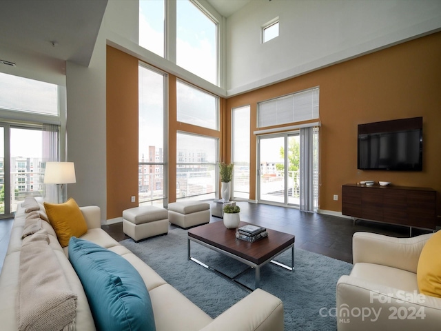 living room featuring a high ceiling and a healthy amount of sunlight