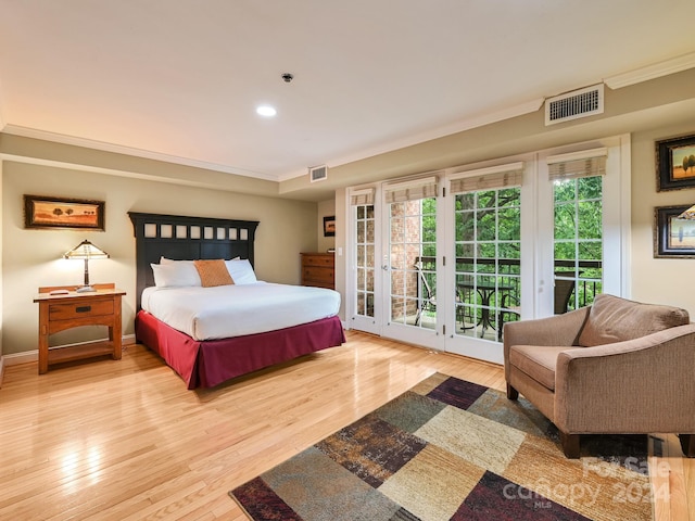 bedroom featuring light hardwood / wood-style floors, crown molding, and access to outside