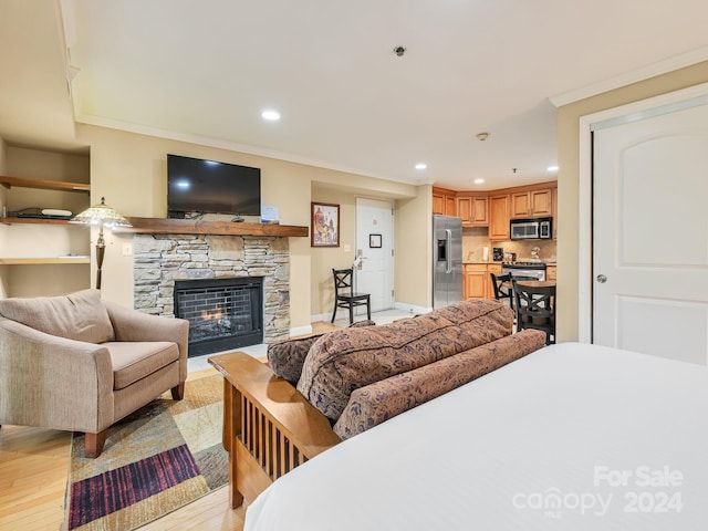 218 Bowling Park Rd Unit 218, Asheville, NC 28803 - bedroom with crown molding, a fireplace, light hardwood / wood-style floors, and stainless steel refrigerator with ice dispenser