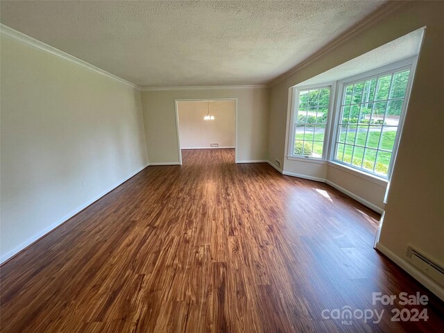 unfurnished room with a baseboard radiator, dark hardwood / wood-style flooring, crown molding, and a textured ceiling