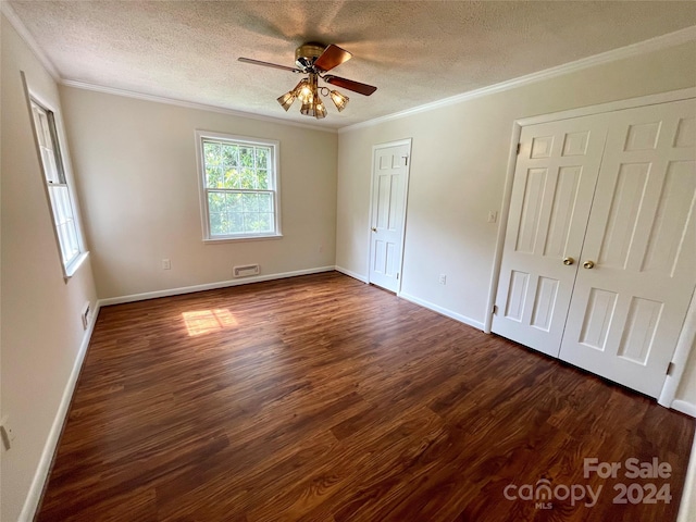 unfurnished bedroom with crown molding, a textured ceiling, ceiling fan, and dark hardwood / wood-style floors