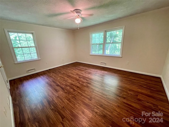 spare room with dark wood-type flooring, a wealth of natural light, and ceiling fan