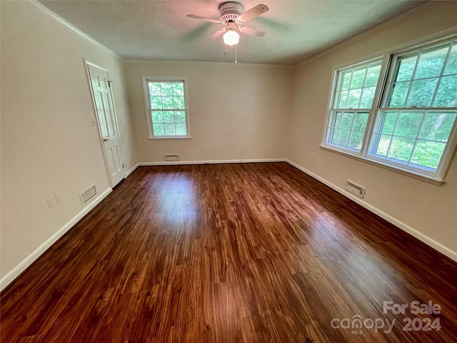 spare room with crown molding, dark wood-type flooring, a textured ceiling, and ceiling fan