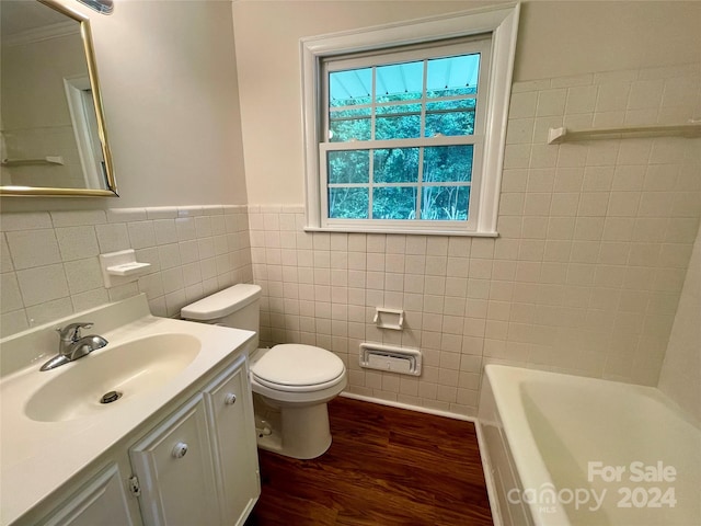 bathroom featuring toilet, tile walls, wood-type flooring, a washtub, and vanity