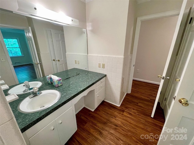 bathroom featuring ornamental molding, vanity, tile walls, and wood-type flooring