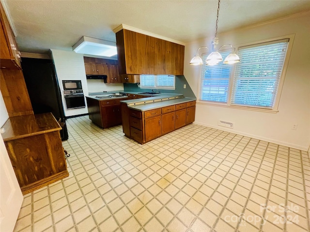 kitchen with a textured ceiling, an inviting chandelier, black appliances, hanging light fixtures, and ornamental molding