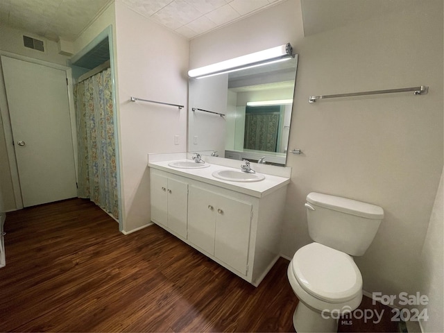 bathroom with vanity, toilet, and hardwood / wood-style floors