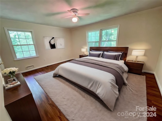 bedroom featuring dark wood-type flooring, ceiling fan, and crown molding