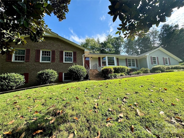 view of front of house with brick siding and a front lawn