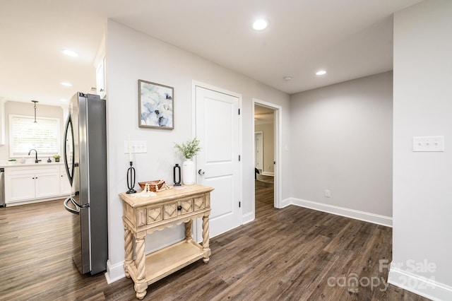 corridor with dark hardwood / wood-style floors and sink