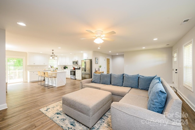 living room with ceiling fan and light hardwood / wood-style flooring