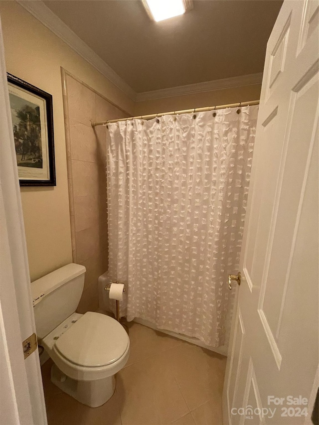 bathroom featuring tile flooring, ornamental molding, and toilet