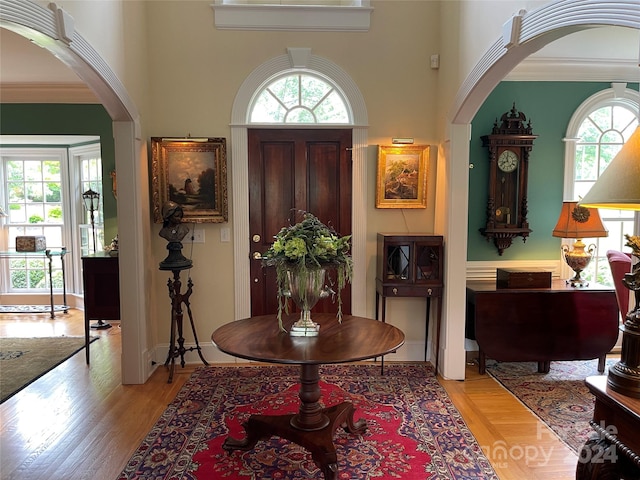 entrance foyer featuring a wealth of natural light, hardwood / wood-style flooring, and ornamental molding