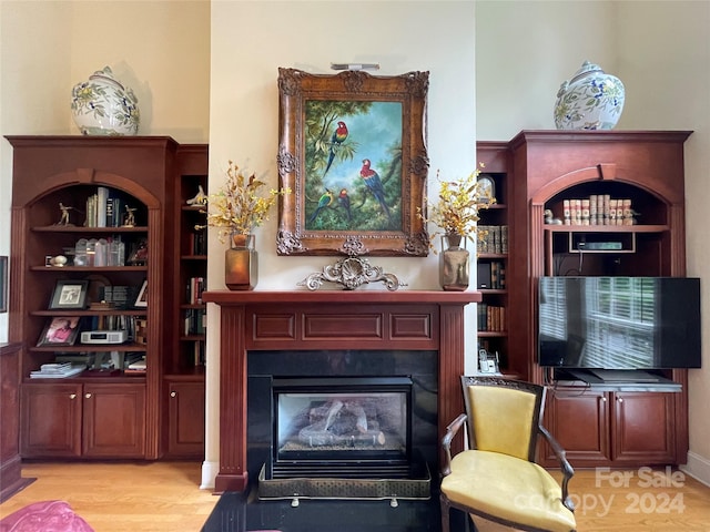 living room featuring built in features and light hardwood / wood-style floors