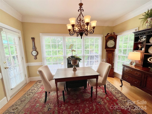 dining room featuring hardwood / wood-style flooring, crown molding, and a chandelier