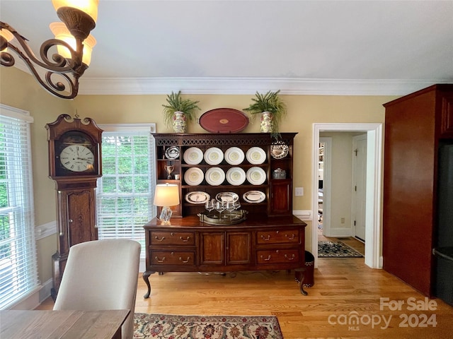 dining room with wood-type flooring, plenty of natural light, and ornamental molding