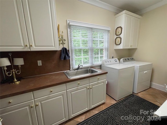 laundry area with cabinets, separate washer and dryer, sink, light tile floors, and ornamental molding