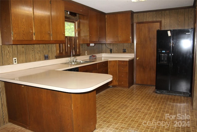 kitchen with black fridge with ice dispenser, kitchen peninsula, crown molding, sink, and light tile floors