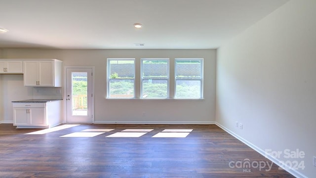 unfurnished living room with dark hardwood / wood-style flooring