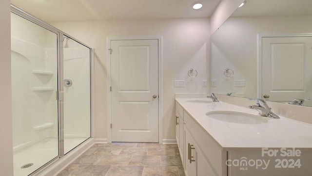 bathroom featuring vanity and a shower with door