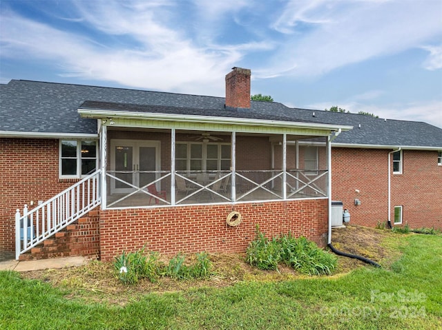 rear view of property featuring a sunroom