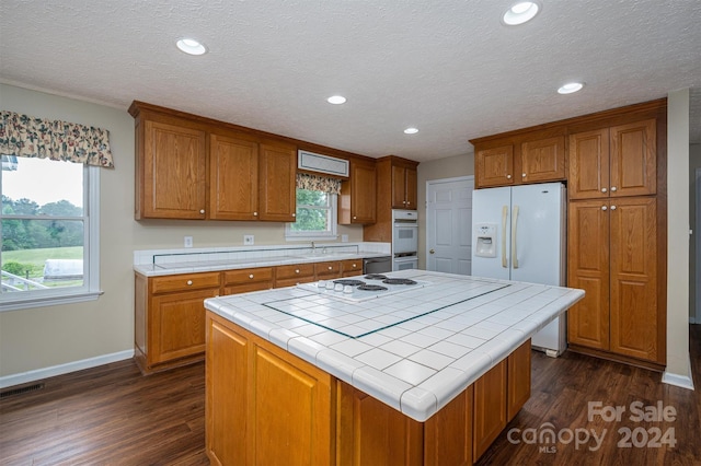 kitchen featuring dark hardwood / wood-style floors, tile counters, and a center island