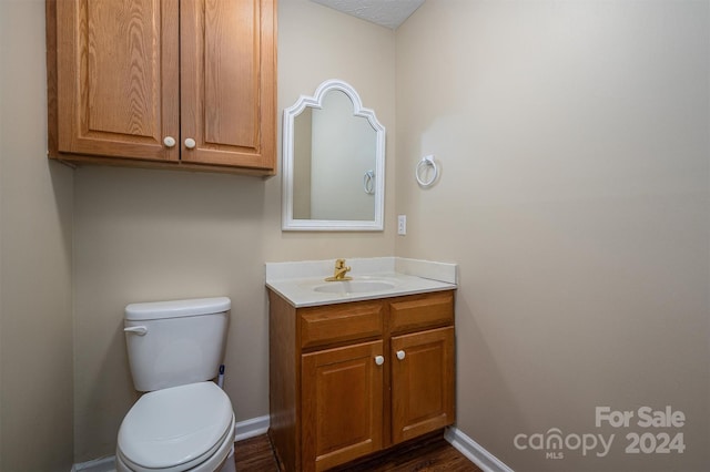 bathroom with wood-type flooring, toilet, and vanity