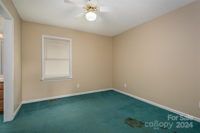 unfurnished room featuring ceiling fan, carpet flooring, and a textured ceiling