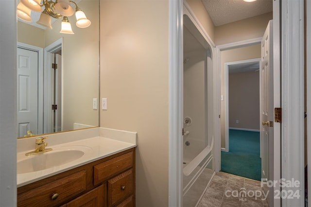 bathroom featuring tile flooring, vanity, and a textured ceiling