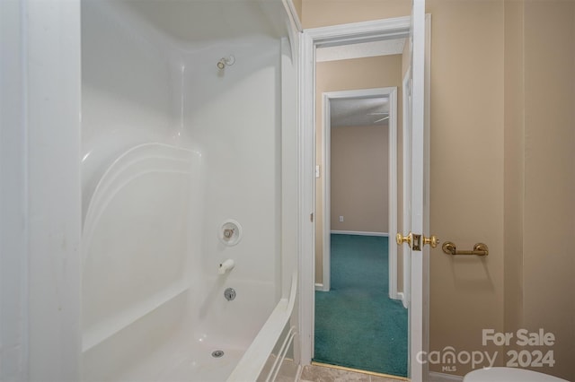 bathroom featuring toilet, a textured ceiling, and shower / bathtub combination