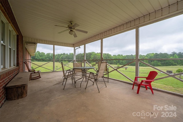 unfurnished sunroom featuring ceiling fan