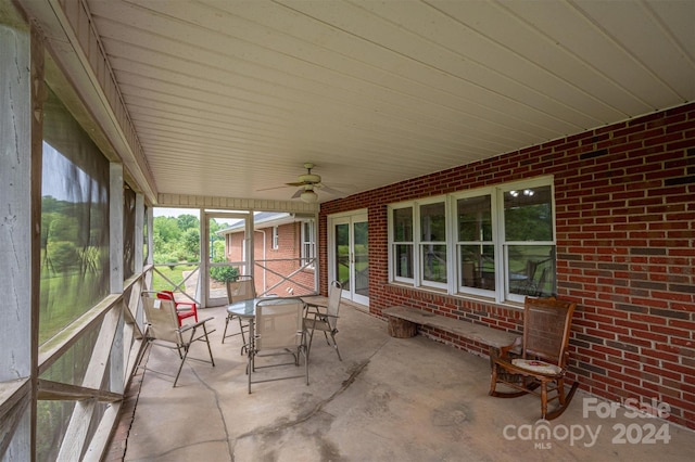 unfurnished sunroom with ceiling fan