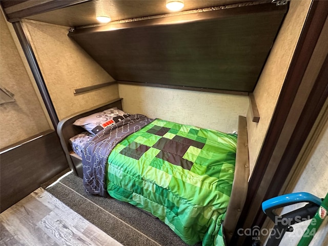 bedroom with vaulted ceiling and dark hardwood / wood-style floors