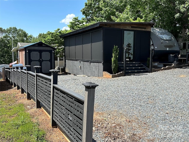 view of front of property featuring a shed