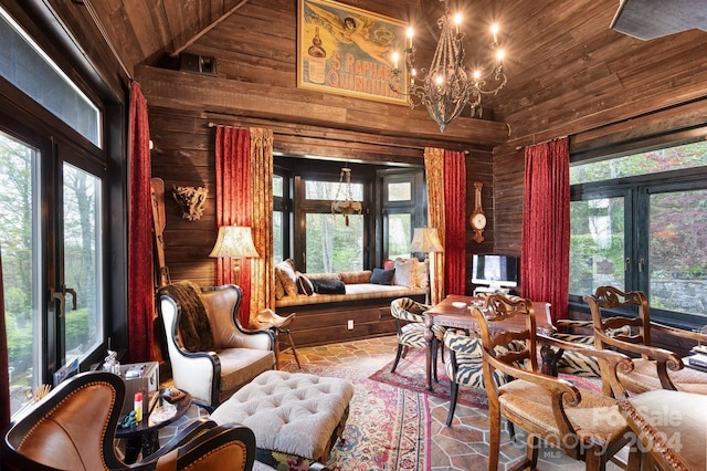 living room with a healthy amount of sunlight, wood ceiling, wood walls, and a chandelier