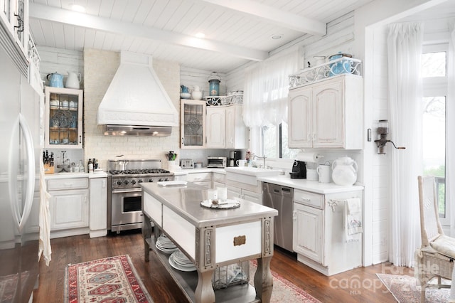 kitchen featuring high quality appliances, dark hardwood / wood-style floors, custom exhaust hood, and beamed ceiling