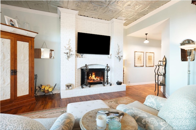 living room with crown molding, hardwood / wood-style flooring, and a fireplace