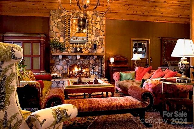 living area featuring a stone fireplace and wood ceiling