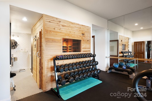 workout room featuring wood walls